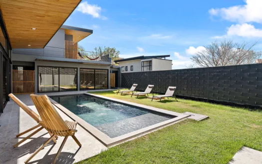 A modern villa in Tamarindo featuring a pool and patio area, showcasing contemporary architecture and outdoor living.