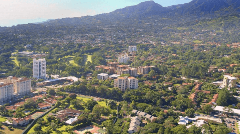 Aerial view showcasing a vibrant cityscape nestled against majestic mountains in the background.