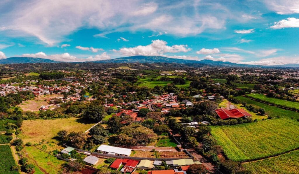 Aerial view of a quaint small town surrounded by lush green fields, showcasing a serene rural landscape.