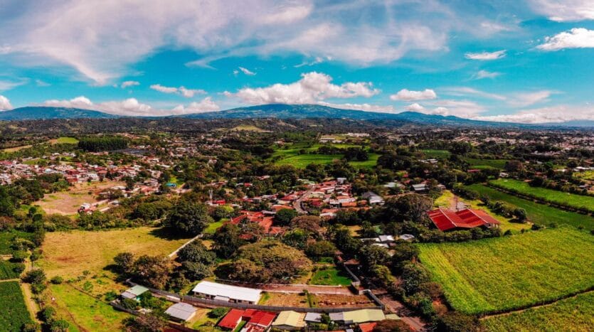 Aerial view of a quaint small town surrounded by lush green fields, showcasing a serene rural landscape.