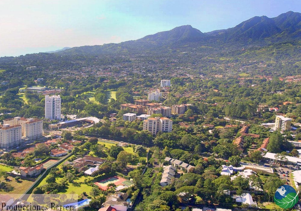 Aerial view showcasing a vibrant cityscape nestled against majestic mountains in the background.