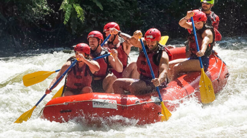 A diverse group of individuals enjoying a rafting adventure on a scenic river, surrounded by lush greenery