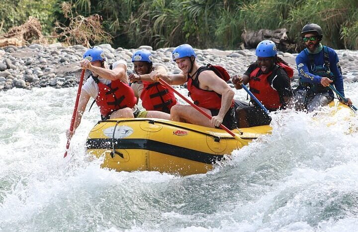 A diverse group of individuals navigating a river in colorful rafts, enjoying an adventurous outdoor experience together.